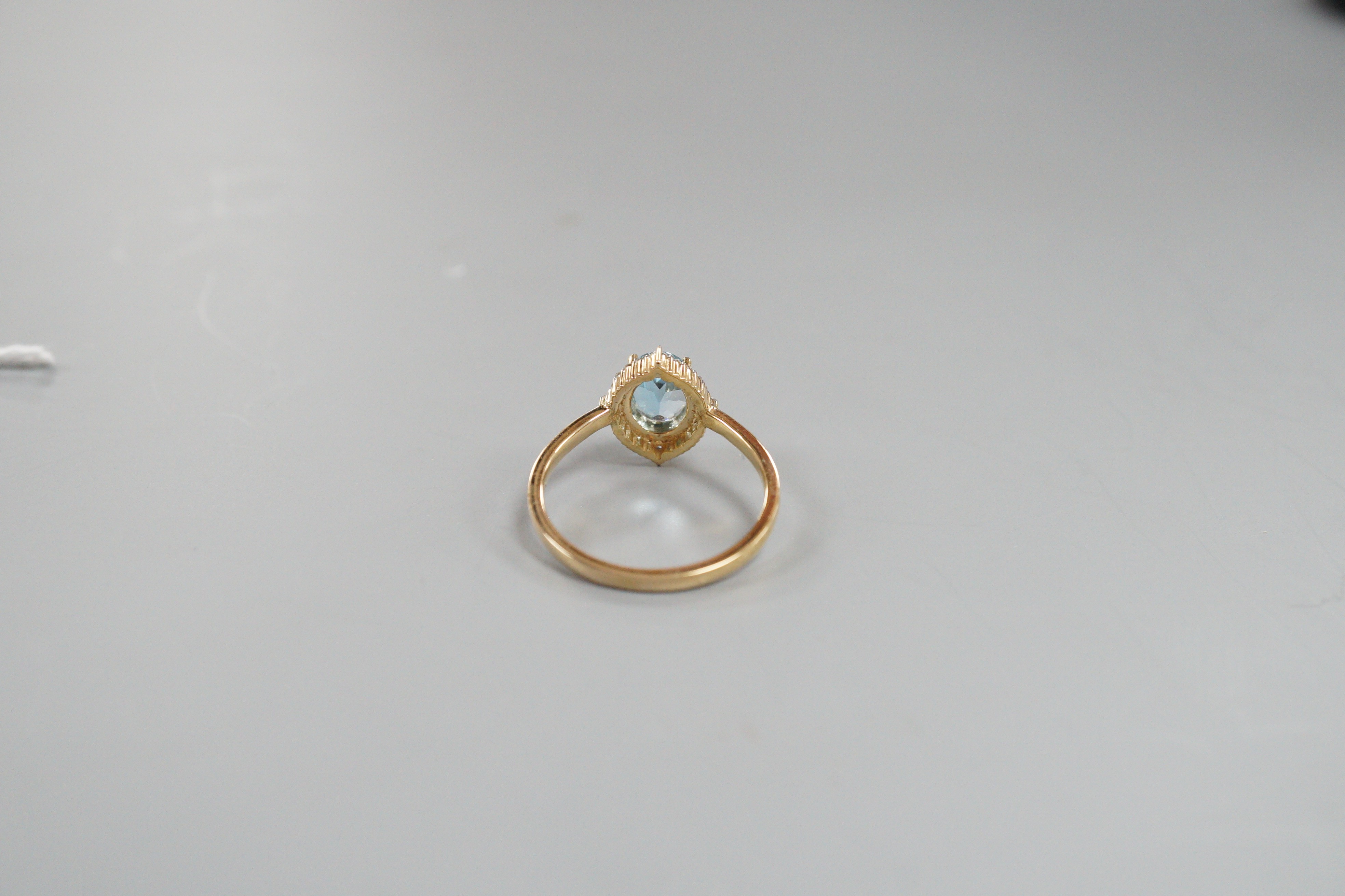 A modern 9k yellow metal, blue topaz and diamond chip set navette shaped cluster ring, size Q, gross weight 3 grams.